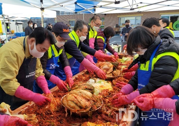지난 12일 한울장애인공동체 '2021 한울김장축제'에 참여한 봉사자들이 김장김치를 만들고 있다. 백운기 용인시장(좌측)도 일손을 보태고 있다.